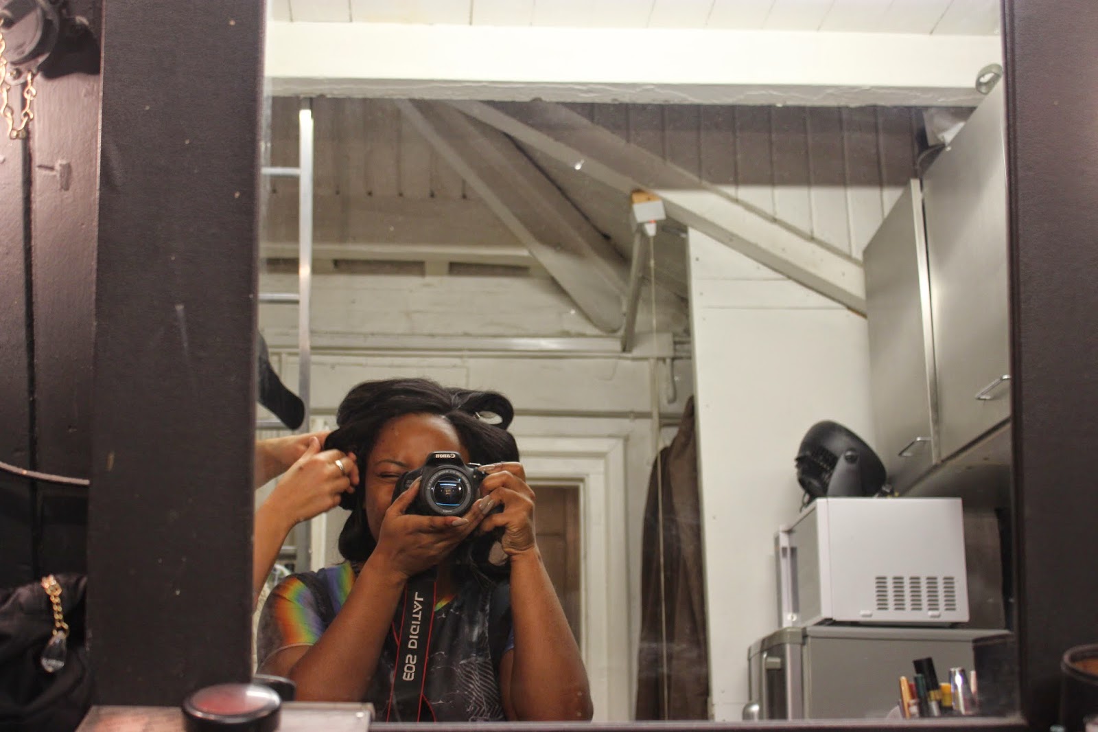 A man talking on a cell phone in front of a mirror