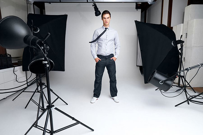 A man standing in a room being photographer by a professional photographer