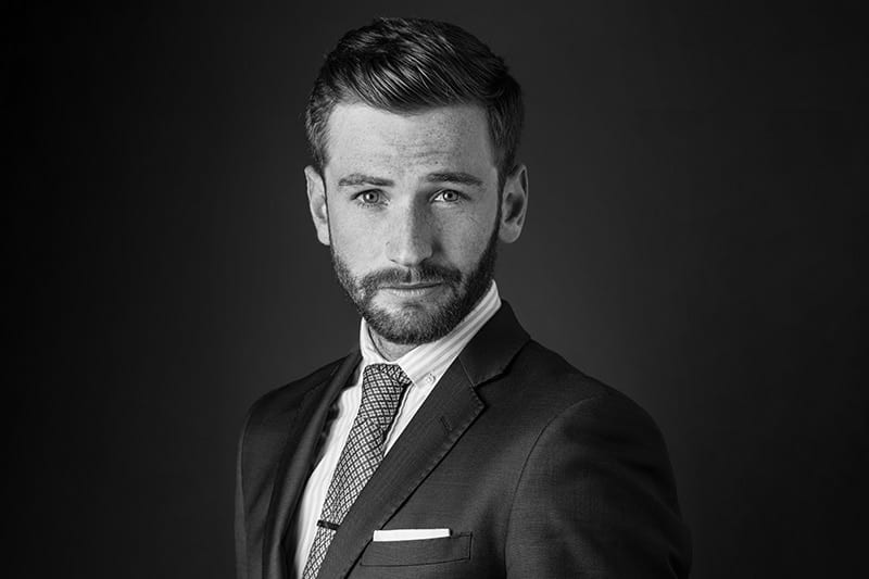 A man wearing a suit and tie looking at the camera