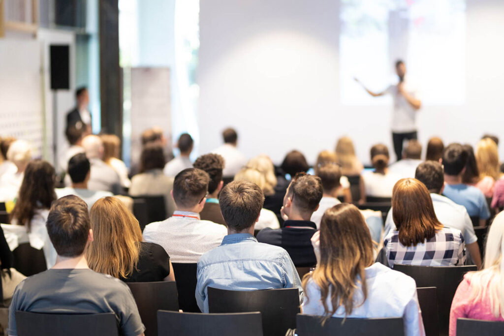 A group of people sitting in front of a crowd