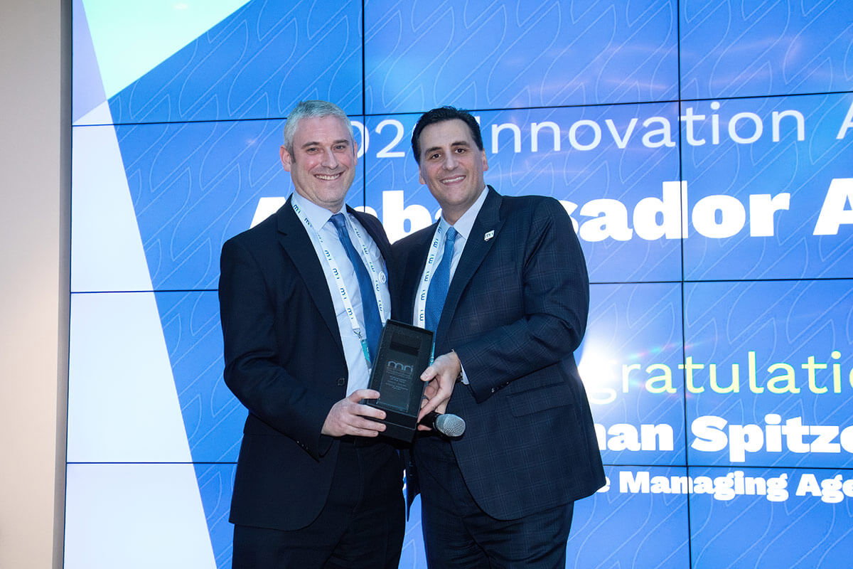 A man wearing a suit and tie standing in front of a building