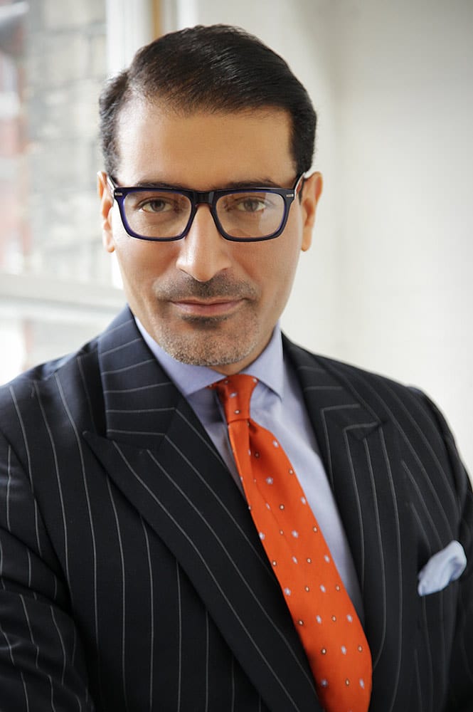Sadegh Kharazi wearing glasses and a suit and tie