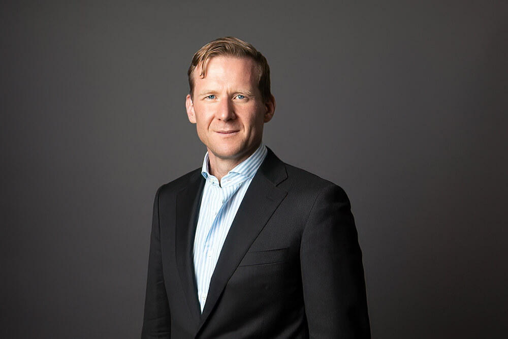 A man wearing a suit and tie smiling at the camera