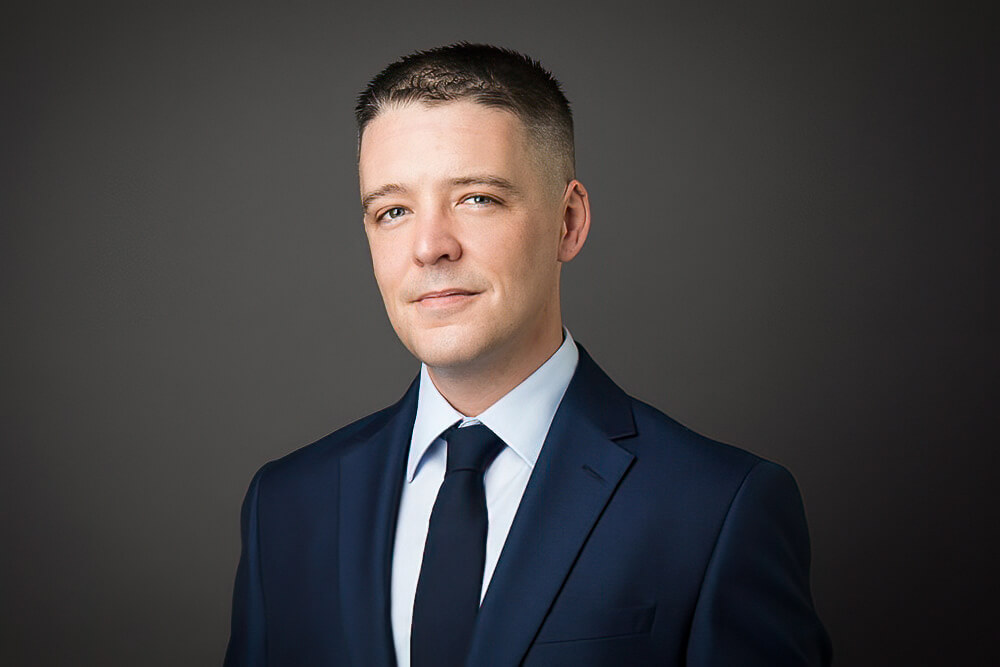 A man wearing a suit and tie looking at the camera