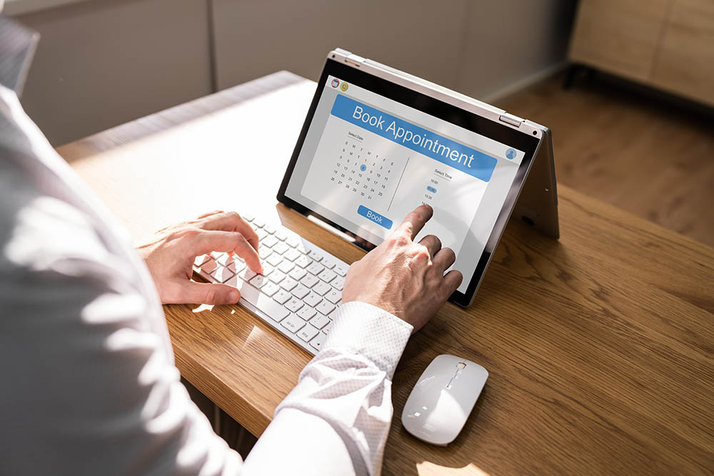 A person using a laptop computer sitting on top of a table