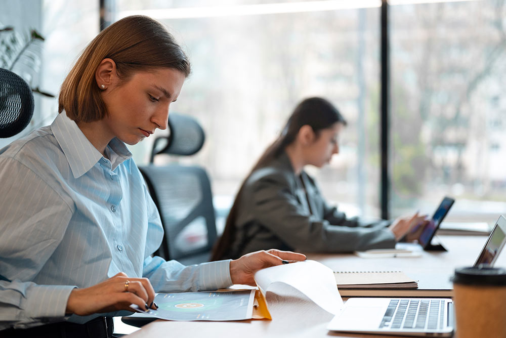 A woman sitting at a desk and using a laptop computer