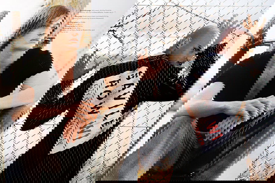 A man and a woman standing next to a fence