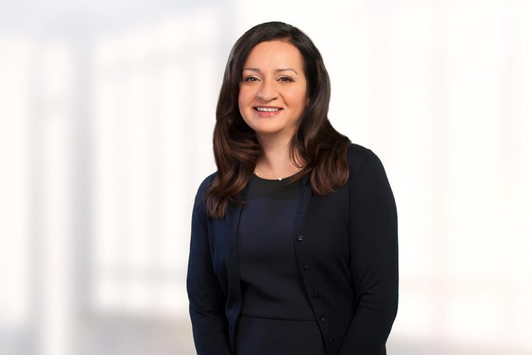 A woman standing in front of a window posing for the camera