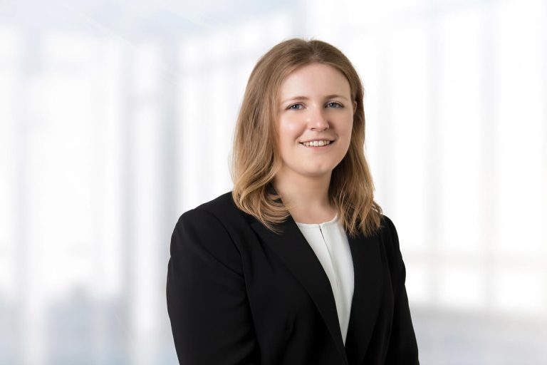 A person wearing a suit and tie smiling at the camera