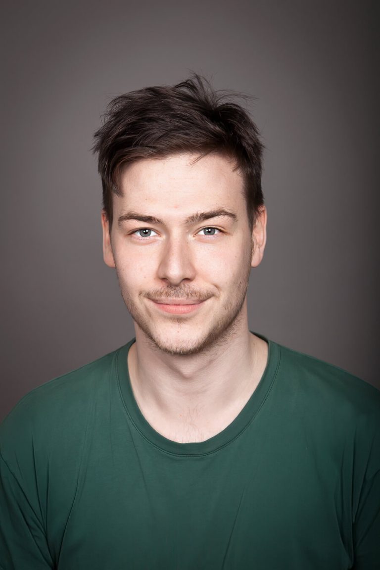 A man in a blue shirt and smiling at the camera
